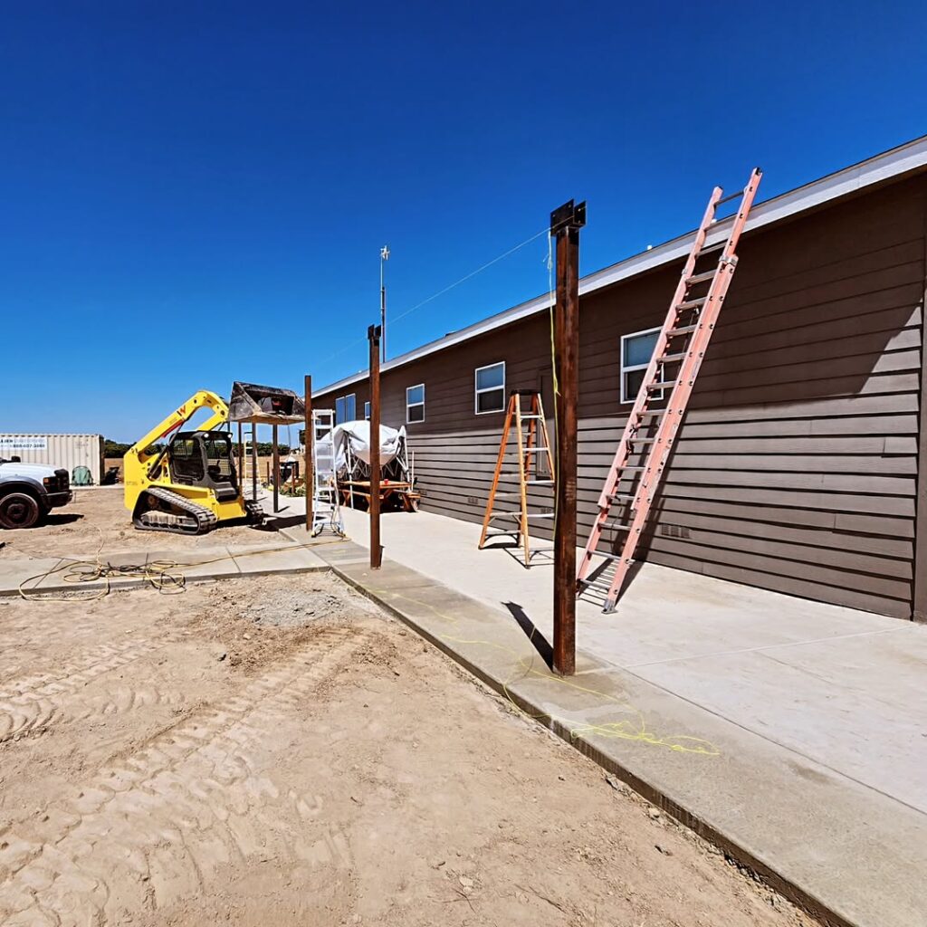 Fence line under construction beside a building