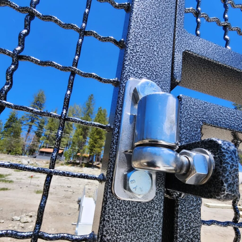 Close up of a welded gate latch and hinge hardware