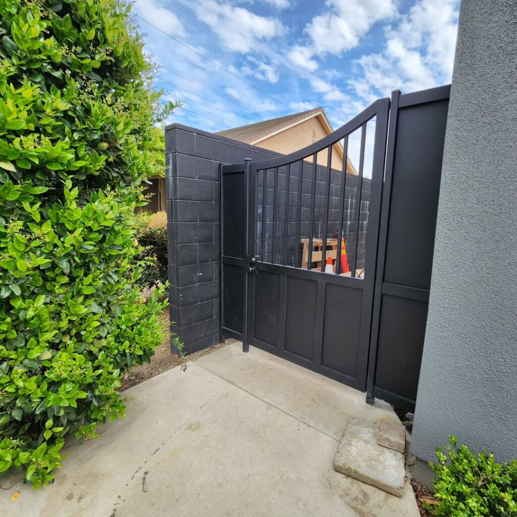 Black steel privacy gate beside a residence