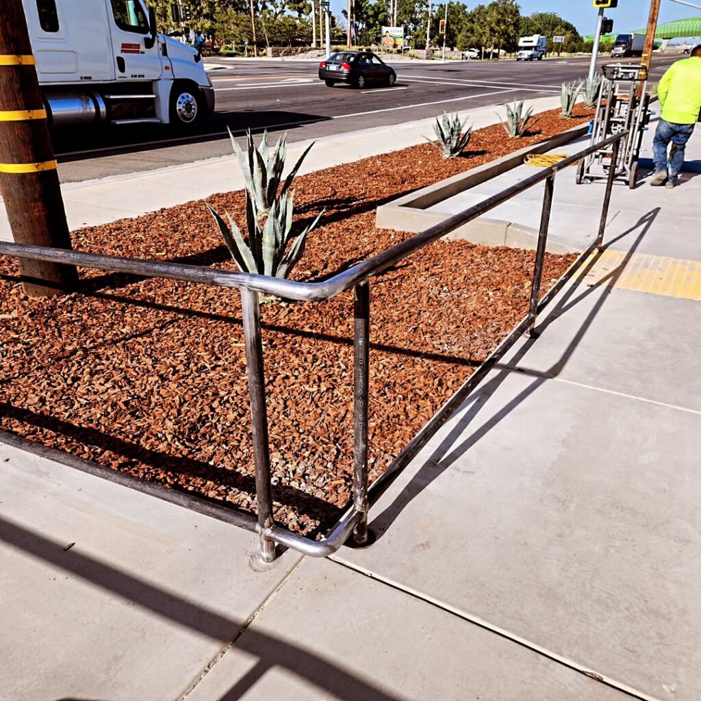 Steel handrail alongside a commercial walkway and planter