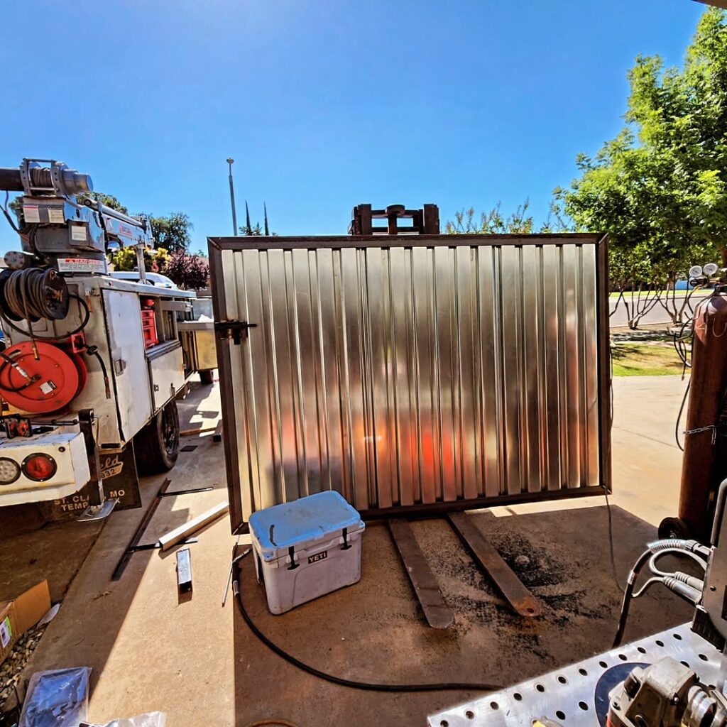 Corrugated metal gate panel being fabricated in the yard