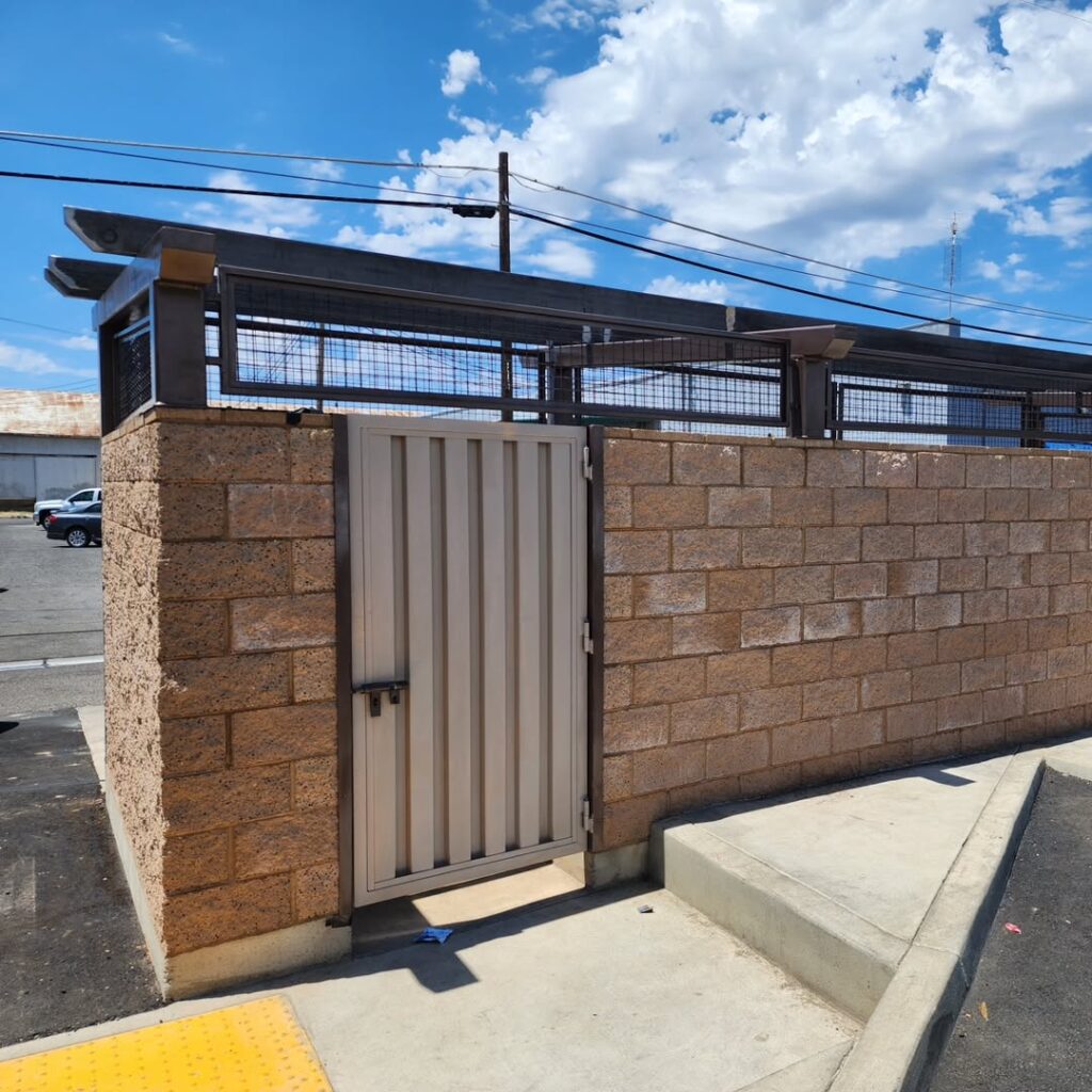 Corrugated steel gate set into a block wall